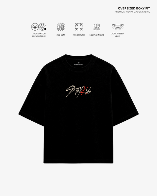 A black oversized short-sleeve T-shirt with a Stussy logo graphic in white and red on the chest, displayed on a light gray background with feature icons and text above it.