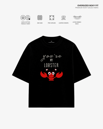 A black oversized short-sleeve T-shirt with a red lobster graphic and the text 'you're MY LOBBER' on the front, shown on a light gray background with feature icons and text above.